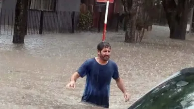 Un vecino intenta cruzar la Plaza Moreno de Villa Elisa.