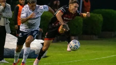 Valentín Pereyra controla la pelota frente a un rival de Quilmes.